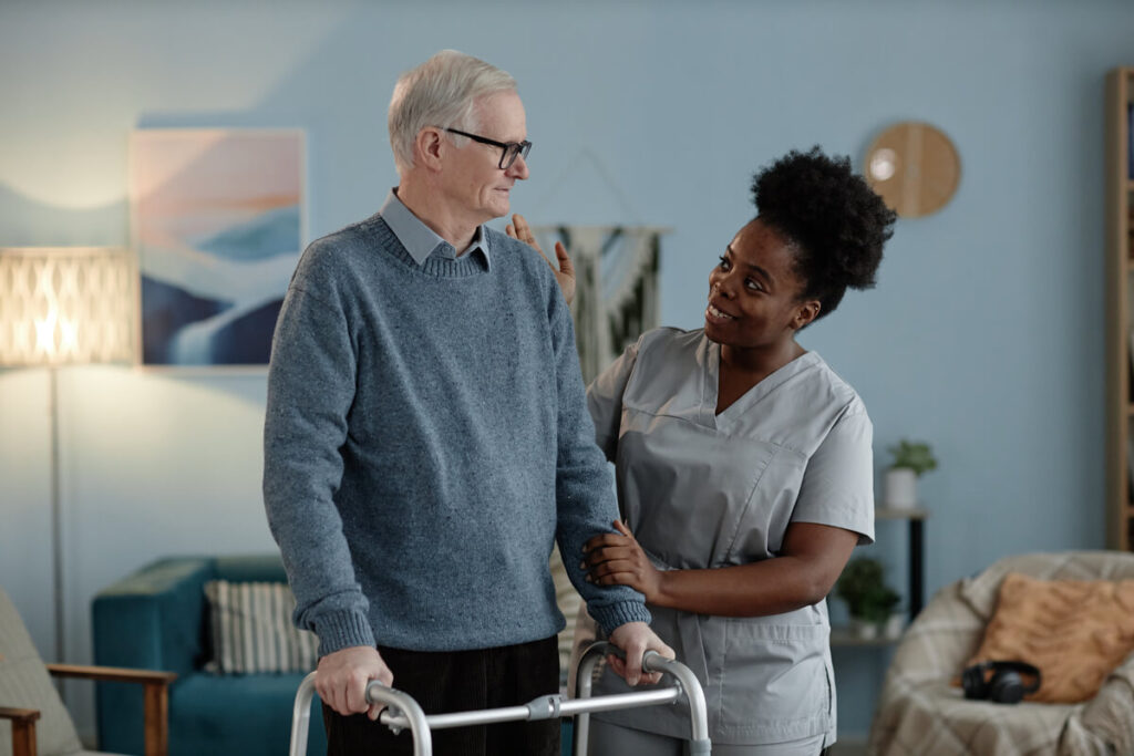 positive-black-female-caregiver-helping-senior-man-URX7Z6X