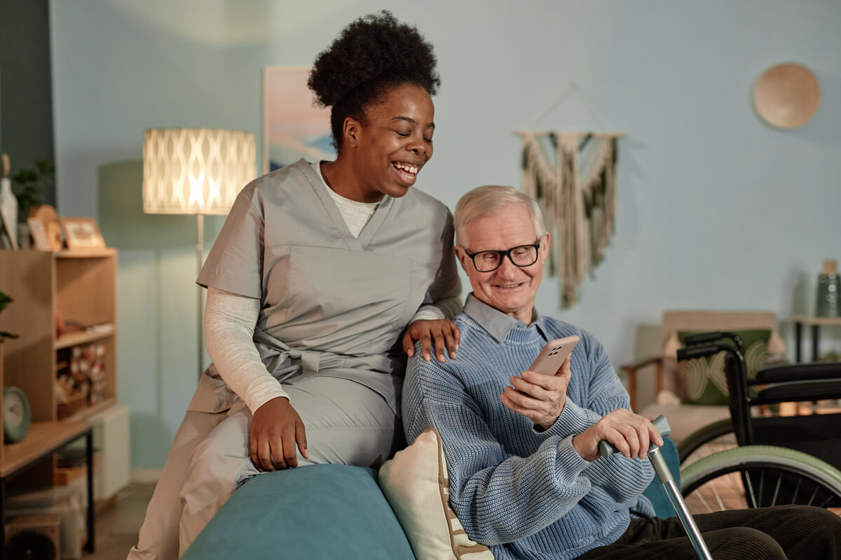 smiling-black-female-caregiver-helping-elderly-man-AVY6Z28